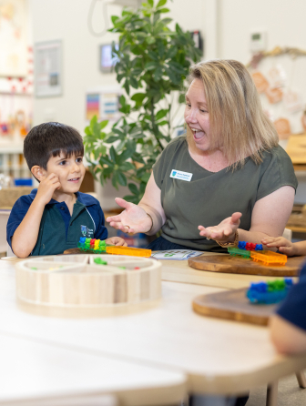 Preschool teacher helping student