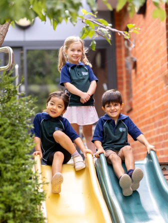 Three children playing on slide
