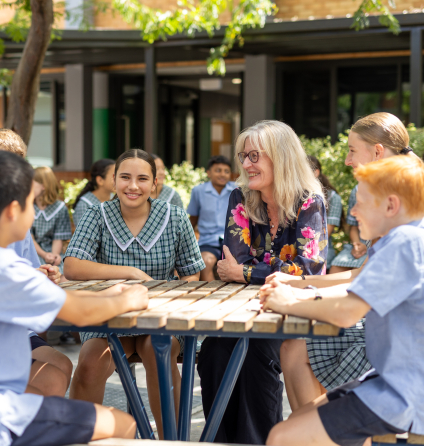 Principal sitting with students